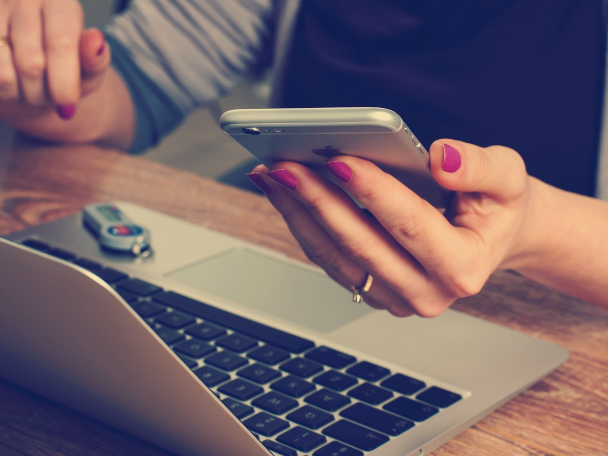 Lady Looking at cell phone and computer